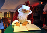 Weihnachtsmann und Märchentante tragen sich ins goldene Gästebuch der Hansestadt Rostock ein